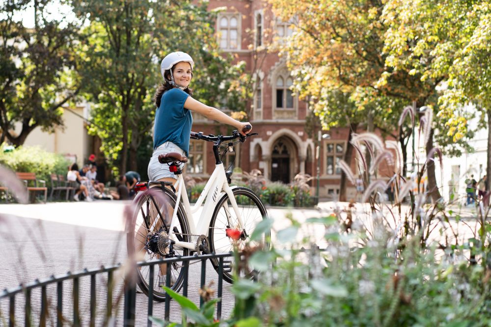 c-bmk-sabine-sattlegger-94.jpg Frau schiebt Gerro E-Bike vor Kirche und schaut nach hinten in die Kamera