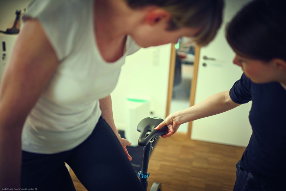 Eine Frau überprüft die korrekte Einstellung des Fahrradsattels.