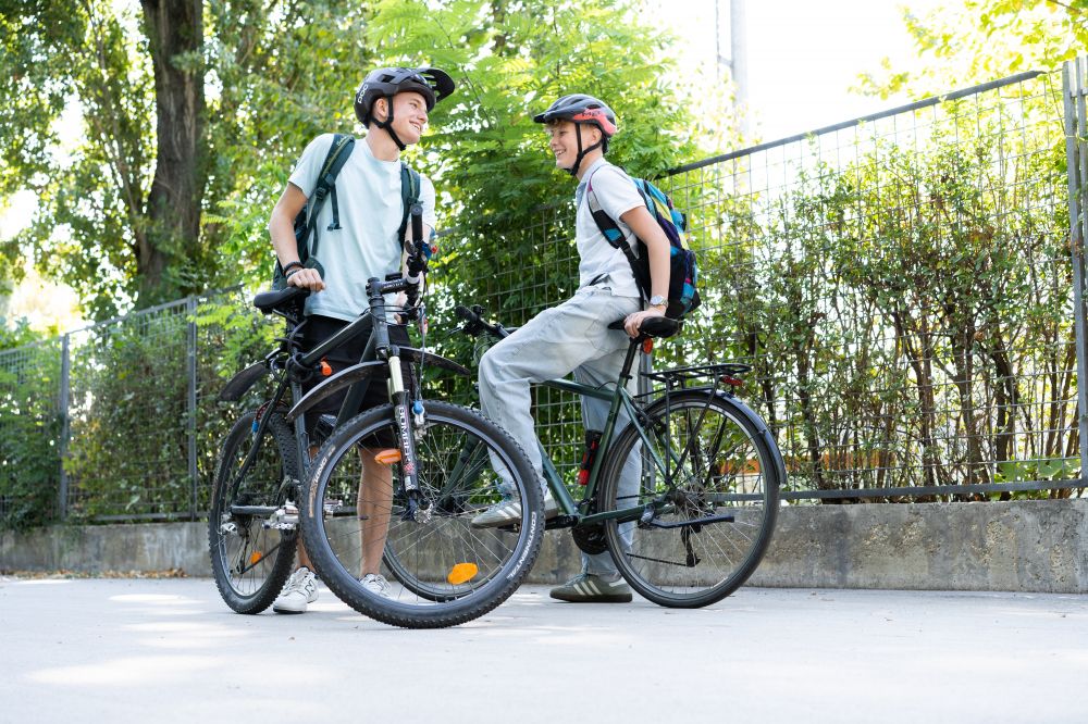 " Jungs die mit Fahrrad stehen und lachen